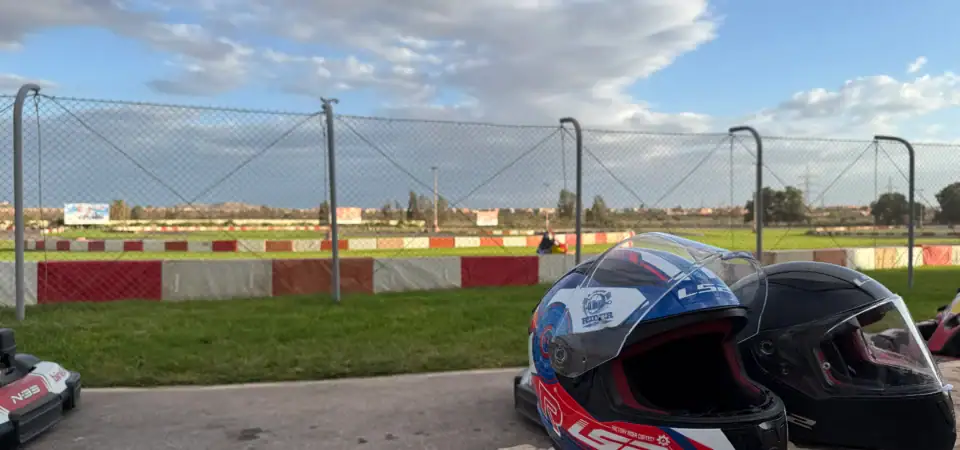 Motorcycle helmets on display near a race track at Marrakech Stay Vip, showcasing a luxurious and exclusive racing experience in Marrakech with scenic sky background.