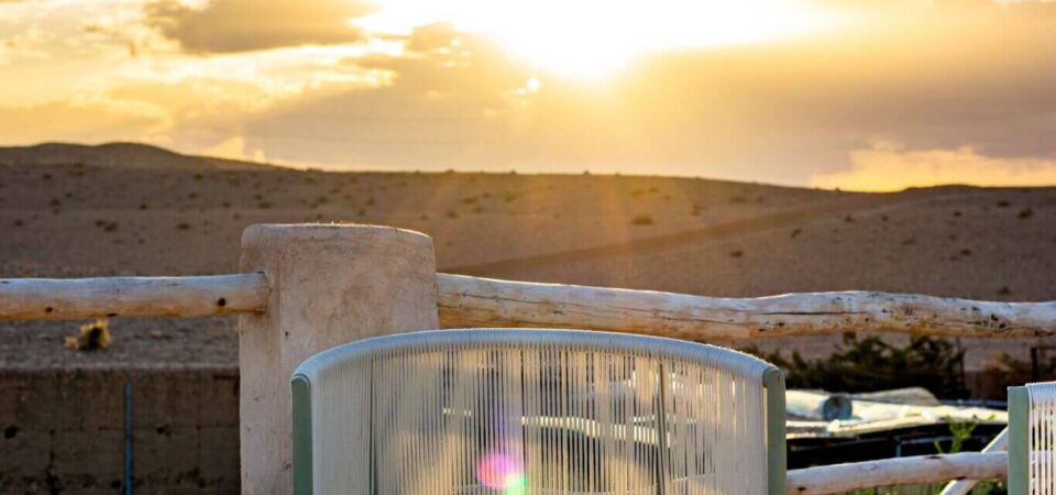 Breathtaking sunset view from Marrakech Stay Vip, highlighting a serene outdoor patio with modern seating, perfect for relaxing and enjoying stunning desert landscapes and vibrant Moroccan sunsets.