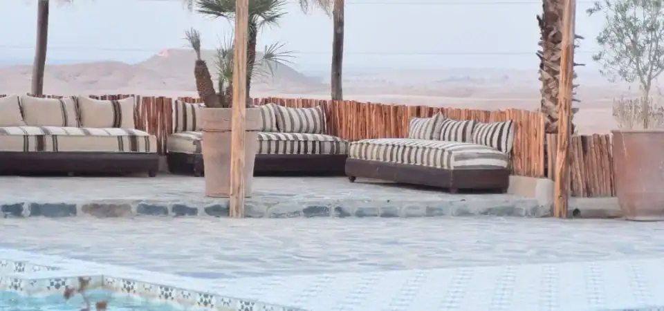 Luxurious outdoor pool with comfortable loungers and Moroccan-inspired decor, perfect for relaxing in Marrakech Stay VIP's desert oasis setting.